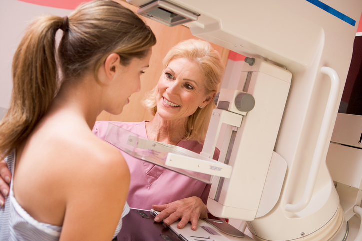 Nurse Assisting Patient Undergoing Mammogram Smiling